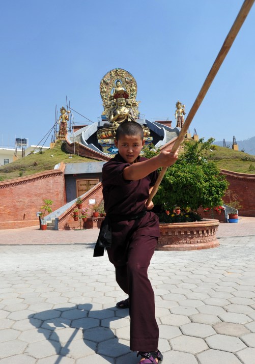 A "Kung Fu" nun demonstrates a pole form at a Tibetan Temple in Nepal. Nuns from this order recently traveled to CERN Switzerland where they displayed their skills and discussed "energy" with a set of confused particle physicists.