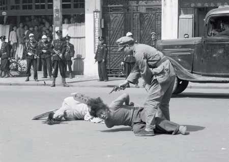 As the Communist advance accelerated in 1949 the Nationalists resorted to more desperate measure in an attempt to hold on to power in at least part of the country. Here a Chinese officer executes two suspected communist agents in the street as a crowd of police officers and civilians looks on.