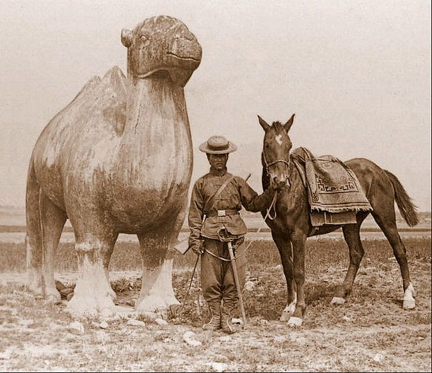 Caravan Guard on the road to Beijing, stops for a photo by an ancient Ming monument, pre-1911. Note the modern carbine and western style saber. Source: Wikimedia.