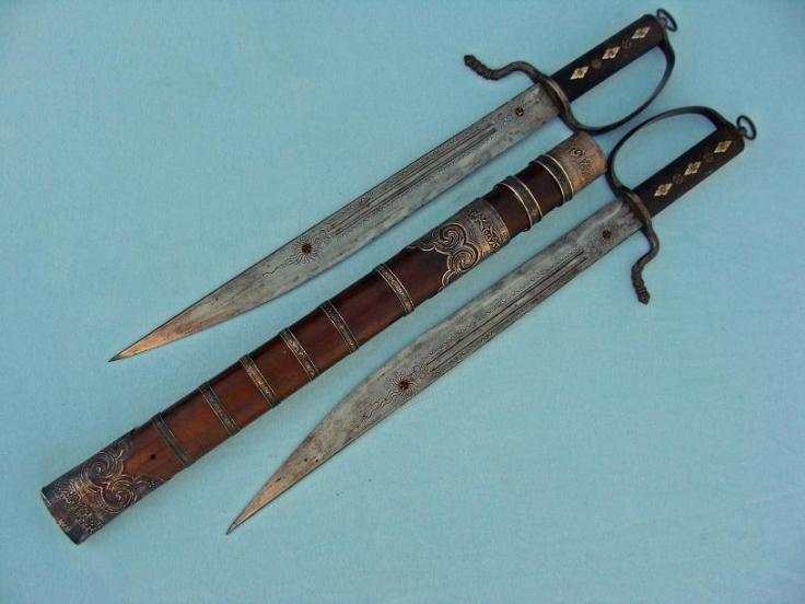 This set of Butterfly Swords has a number of unusual features. Perhaps the most striking are its wood (rather than leather) scabbard and high degree on ornamentation. These probably date to the late 19th century and are 49 cm in length. Photo courtesy of http://www.swordsantiqueweapons.com.