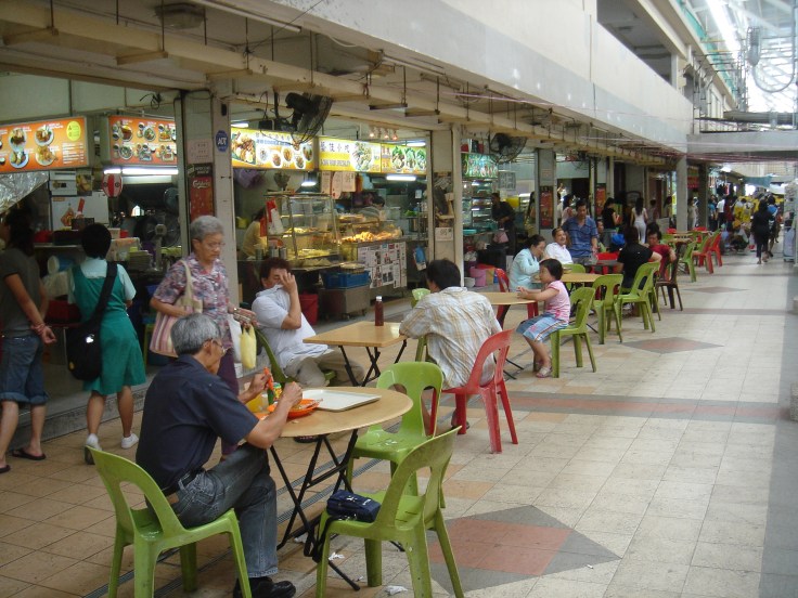 A typical "coffee-shop" in Singapore. To Americans these local iconic institutions resemble outdoor food-courts. Farrer reports that traditional martial arts masters would often socialize for hours with their students after class in the local coffee-shops. In doing so they passed on the deep social knowledge that allowed the traditional martial arts to become a powerful form of social capital. Source: Wikimedia. 