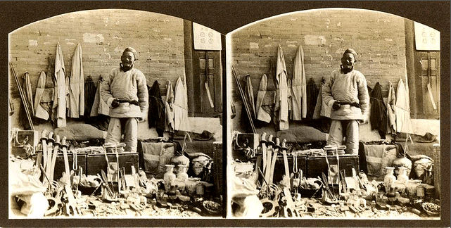 Stereoscope image of a junk dealer selling swords.  Probably late 19th century. 