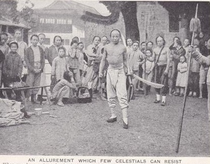 A typical market place demonstration.  Note the two oxtailed Dao's held by the central figure.  these swords are very similar to the ones being sold above.