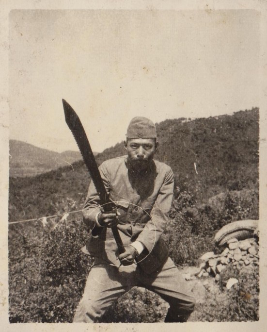 A captured Chinese dadao being held by a Japanese soldier.  Note the unique saw back blade.  Source: Author's Personal Collection.
