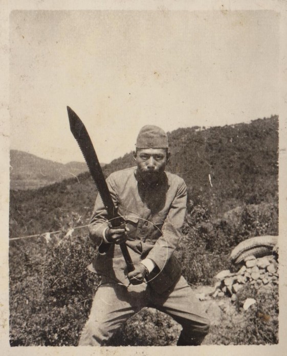 A captured Chinese dadao being held by a Japanese soldier. Note the unique saw back blade. Source: Author's Personal Collection.