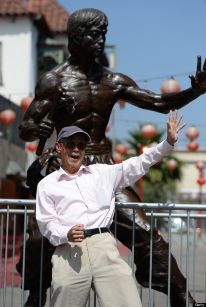 Another individual sharing a moment with the image of Bruce Lee, LA Chinatown.  Source: Huffington Post.