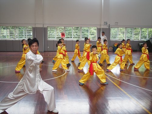 Chen Daoqing, a third-generation practitioner of Mian Quan, leads students practicing moves at Shanghai Kunming Primary School. Source: Global Times