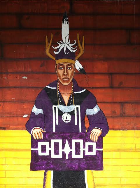 A detail of a larger mural painted on a parking garage next to the Ithaca Commons (in Ithaca NY) showing an Iroquois chief holding a wampum belt that represents the nations of the confederacy.  Photo by Benjamin Judkins.