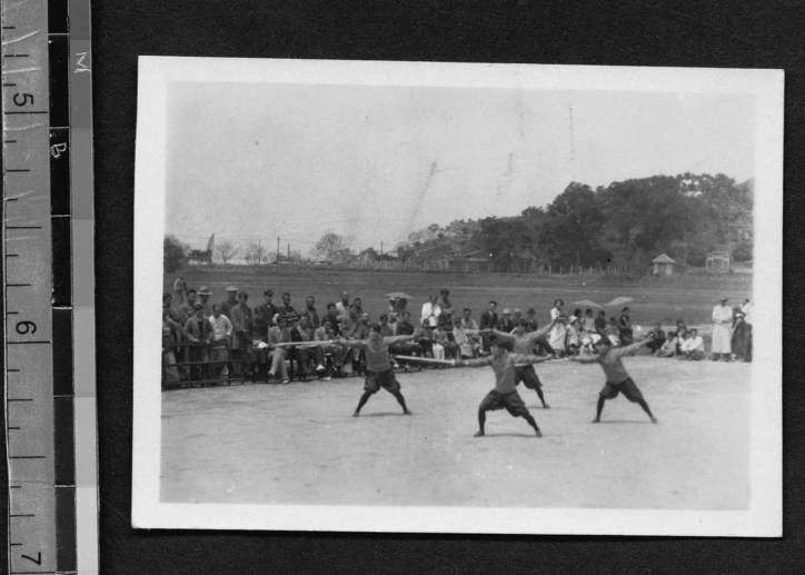 The archival note with this photo reads as follows: "F. C. U. student activities "F. C. U. Girl athletes Chinese boxing" Four students in blouses and bloomers, holding sticks in their right hands, perform a move on a dirt field surrounded by walls. A crowd of spectators watches. Hills visible in background."  Source: http://findit.library.yale.edu