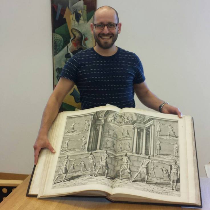 Dr. Sixt Wetzler showing off a fight book from the collection of the German Blade Museum. 